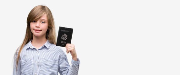 Young blonde toddler holding american passport with a happy face standing and smiling with a confident smile showing teeth