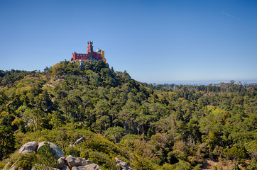 Fototapeta na wymiar A distant view of Pena Palace viewed from the Castle of the Moors from Sintra, Portugal
