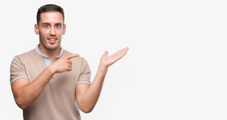 Handsome young man very happy pointing with hand and finger