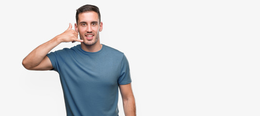 Naklejka premium Handsome young casual man smiling doing phone gesture with hand and fingers like talking on the telephone. Communicating concepts.