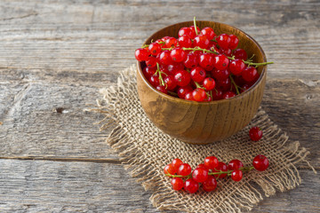 Fresh red currant berries on wooden background
