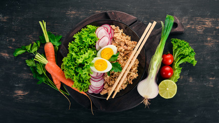 Healthy food. Oatmeal, lettuce, radish, egg. On a wooden background. Top view. Free copy space.