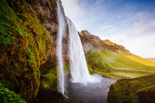 Perfect view of famous powerful Seljalandfoss waterfall in sunlight.