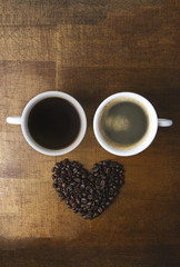 Coffee cups  on wooden table background, coffee beans heart