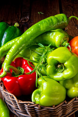 various harvested peppers and hot peppers in basket