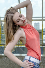 Beautiful young girl with long hair dreamily waiting at the bridge
