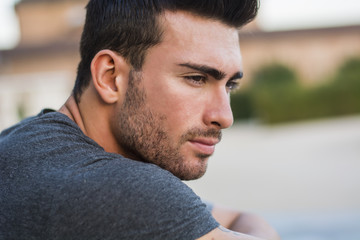 Fototapeta premium Handsome muscular man with tattoo posing in European city center, Turin, Italy