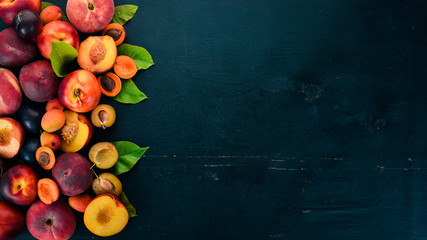 Fresh fruits. Apricot, peach, plums, nectarines. On a wooden background. Top view. Free space for your text.