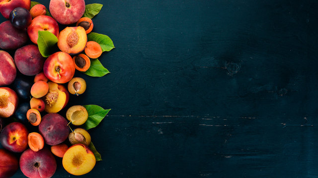 Fresh Fruits. Apricot, Peach, Plums, Nectarines. On A Wooden Background. Top View. Free Space For Your Text.