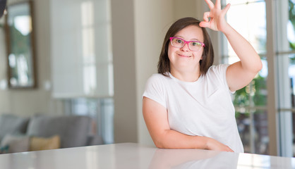 Down syndrome woman at home doing ok sign with fingers, excellent symbol
