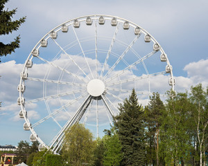 Ferris wheel in the city park of attractions. Recreation and entertainment for adults and children....