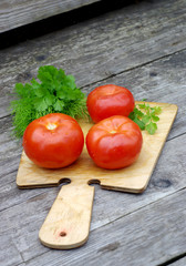 Tomatoes, parsley and dill on a cutting board