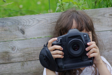 Little girl takes pictures on a big camera