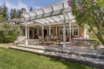 Lovely outdoor deck patio space with white dining pergola. - obrazy, fototapety, plakaty