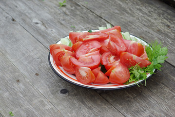 Sliced tomatoes, cucumbers, parsley and dill on a plate