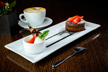 Delicious sweet muffin with chocolate in the white plate in a re