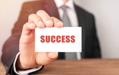Businessman holding a card with text Success