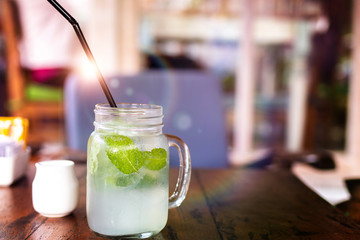 Fresh drink lemonade mojito on wooden table. Mojitos with mint leaves, lime and ice, outdoor.