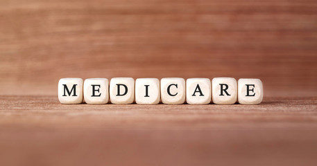 Word MEDICARE made with wood building blocks - obrazy, fototapety, plakaty
