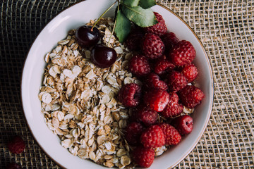 Delicious, healthy breakfast.Porridge with berries.Ecofriendly.Oatmeal porridge with raspberries and cherries.The idea for breakfast on black background. Natural, dietary food.Good morning. Life style