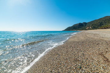 Fototapeta na wymiar Pebbles and blue sea in Perdepera coastline