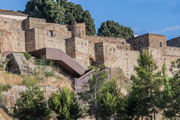 Naklejka premium External view of Alcazaba Walls - palatial fortress in Malaga built in XI century. Fortress palace, whose name in Arabic means citadel, is one of city's historical monuments. Malaga, Andalusia, Spain.
