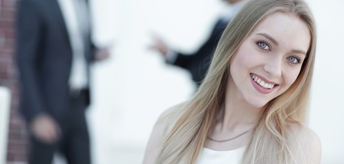 close-up portrait of a young woman against the background of colleagues