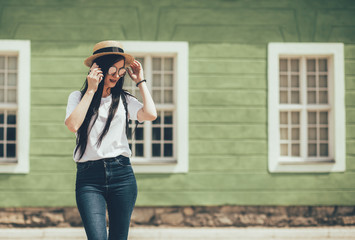 Pretty brunette woman internet blogger talking by smartphone in old city