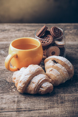 tea and croissant on wooden table