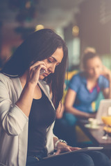 Young woman using mobile phone in front of her team in startup office