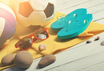 football in the sand with sandals at the beach pier near waves