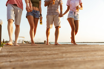 Group of friends walking outdoors on the beach.
