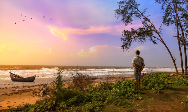 Rural fisherman at the beach at sunset with view of wooden fishing boat at Chandpur beach Digha, West Bengal, India.