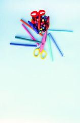 School supplies. Back to School design elements. Colorful markers and scissors on light blue background.