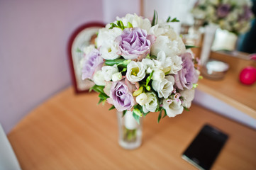 Close-up photo of bridal bouquet on the table.