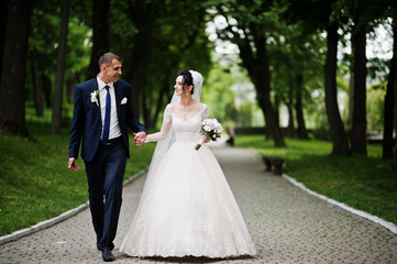 Naklejka premium Wedding couple walking and enjoying themselves in the park on a beautiful day.