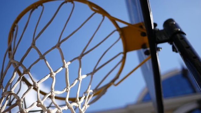 Thrown ball flies right into the basketball hoop on outdoors playground