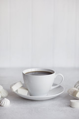 Cup of coffee on white background. Marshmallows, sweets and coffee beans.