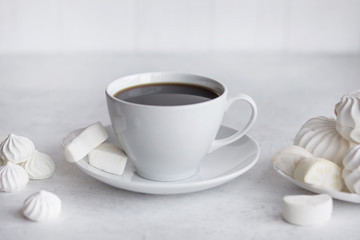 Cup of coffee on white background. Marshmallows and sweets.