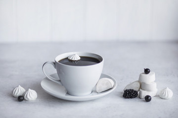 Cup of coffee, white background. Marshmallows, blue, black berries. Blueberries, blackberries, black currants.