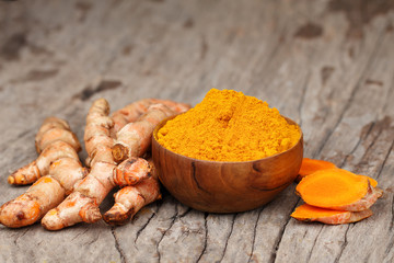 Turmeric powder in wooden bowls on wooden table