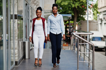 Two stylish african american girls friends posed outdoor of steets city.