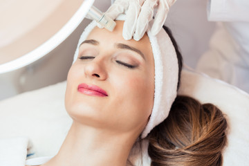 Close-up of the face of a woman relaxing during non-surgical facelift treatment in a contemporary beauty salon with innovative technology