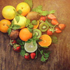 Naklejka na ściany i meble citrus fruits and strawberries on a wooden background