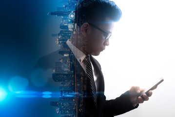 The double exposure image of the businessman using a smartphone overlay with cityscape image. The concept of modern life, business, city life and internet of things.