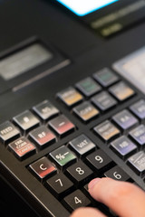 cash register installed on counter for accepting order from customer.sales man entering amount on electronic cash register in coffee shop and retail store.restaurant cashier typing on cash register.