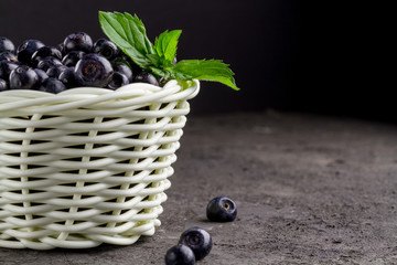 White basket of blueberries with a slice of fresh mint. Copy space