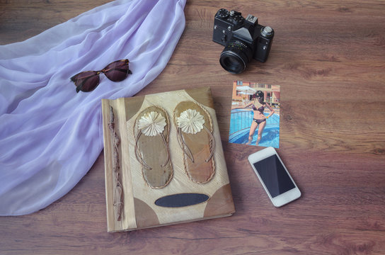 photo album with photo camera, phone, parero and sunglasses