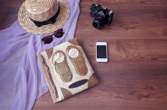 photo album with photo camera, telephone, parero, straw hat and sunglasses