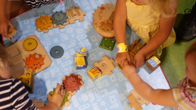 Children hands play a table toy constructor designer sets games